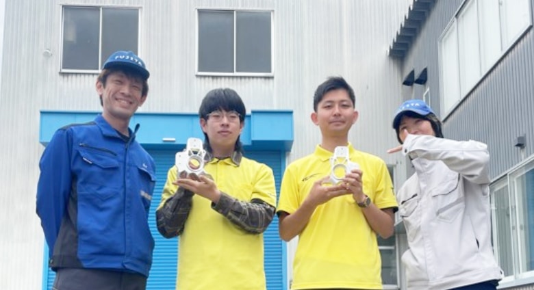 富山大学の学生フォーミュラチームと完成した部品を手にするフジタのスタッフ